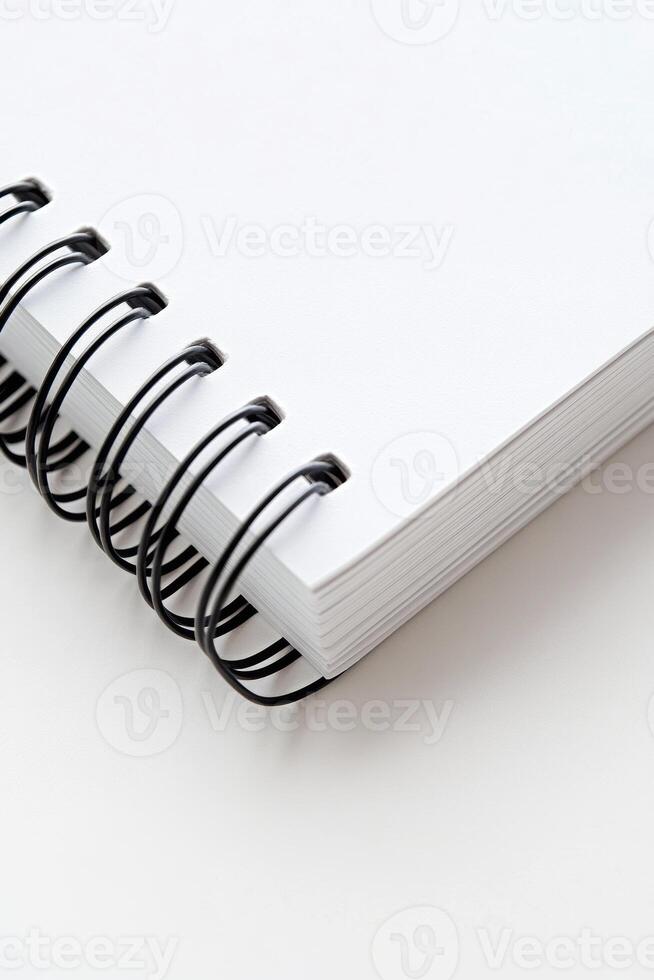 Blank spiral notebook resting on a flat surface ready for notes or sketches photo