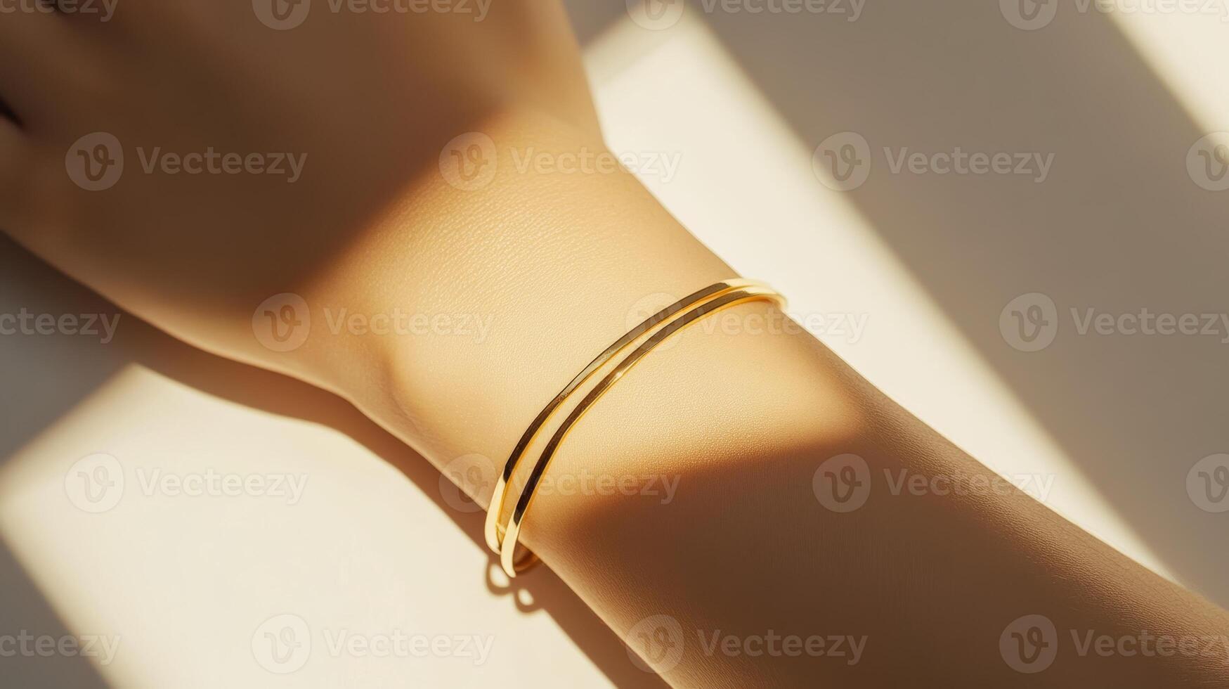 Elegant gold bangle resting on a wrist, illuminated by soft sunlight, showcasing a minimalist design and luxury craftsmanship photo