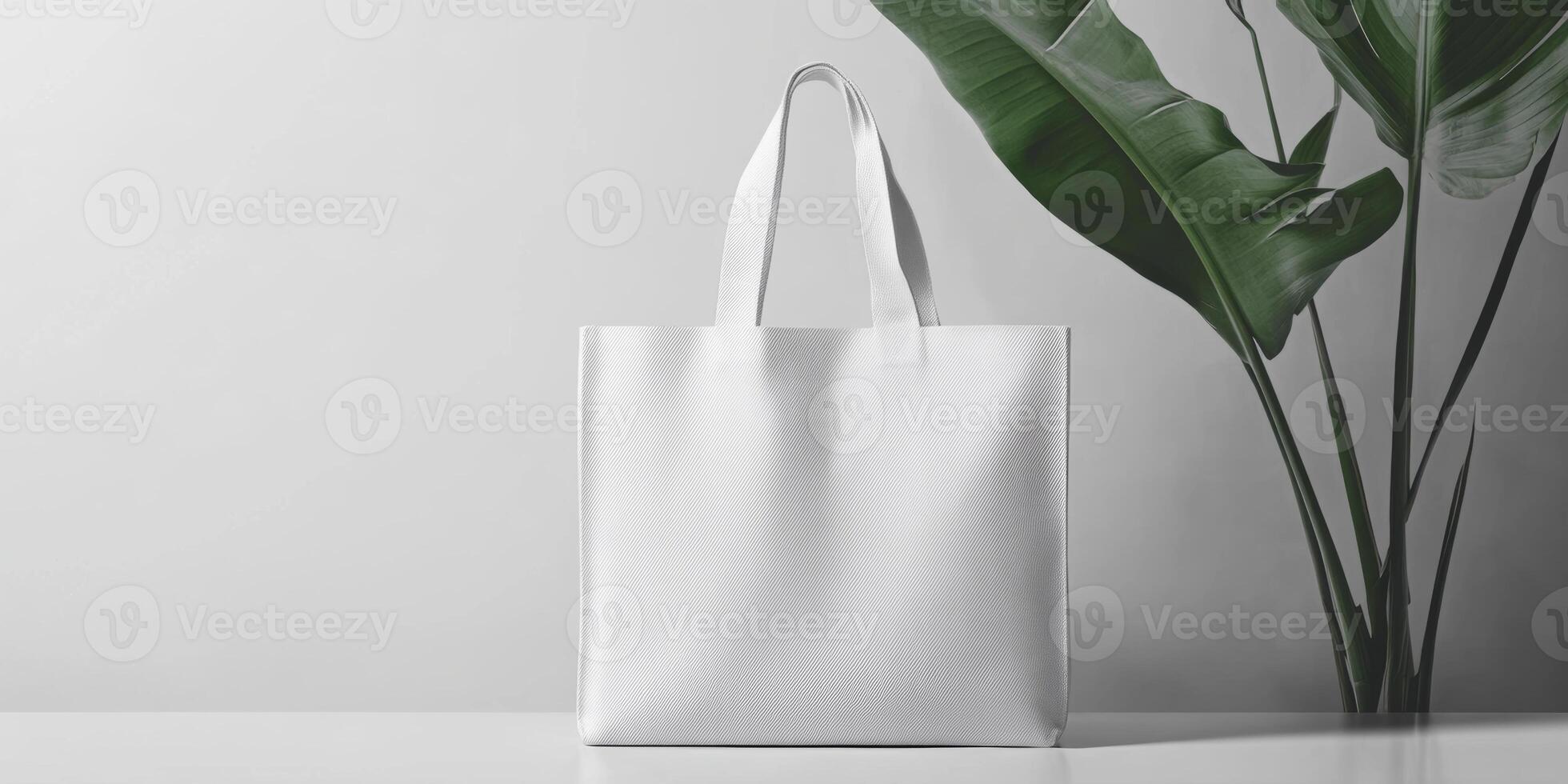 Stylish white tote bag displayed against a minimalistic background with green plant accents photo