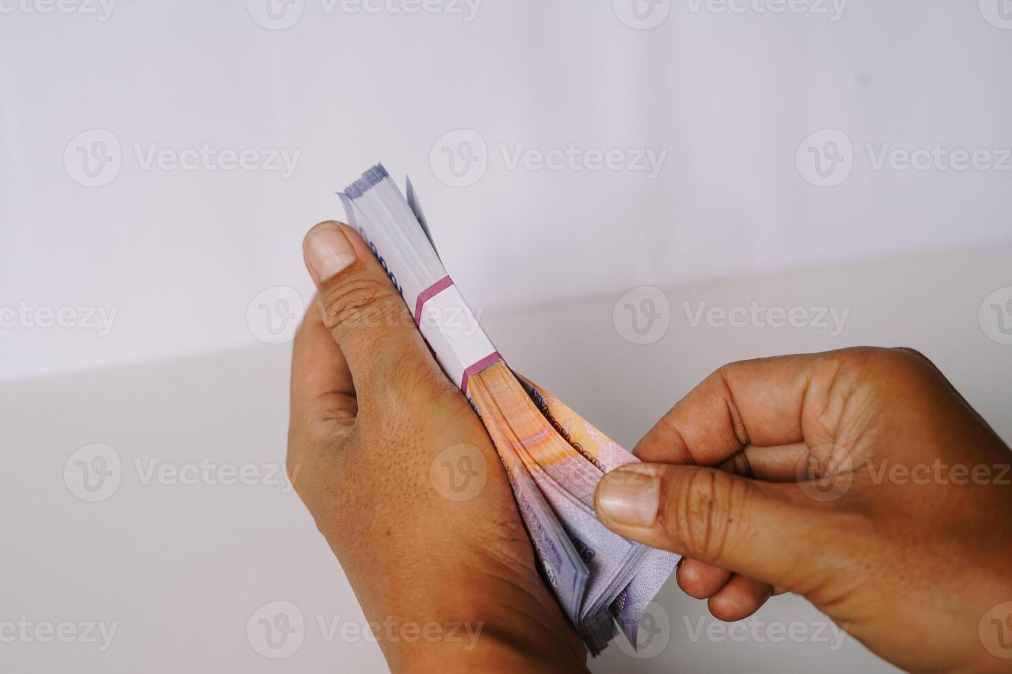 Hands meticulously counting bundle currency notes isolated white background photo