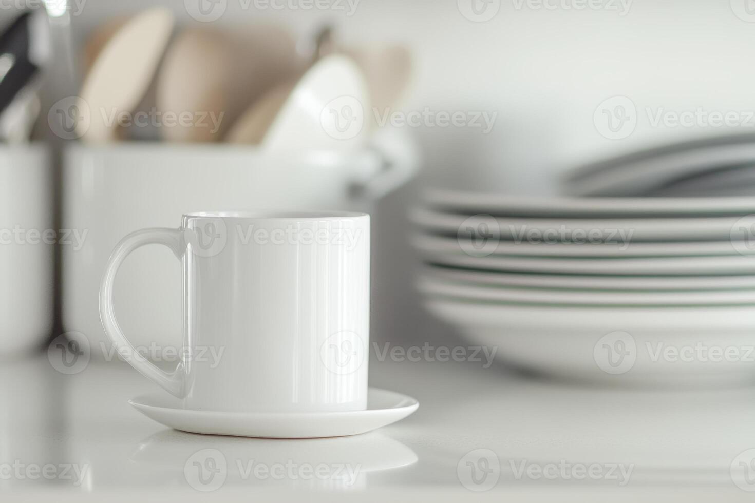 White ceramic cup with saucer placed on a kitchen counter surrounded by dishware in soft light photo