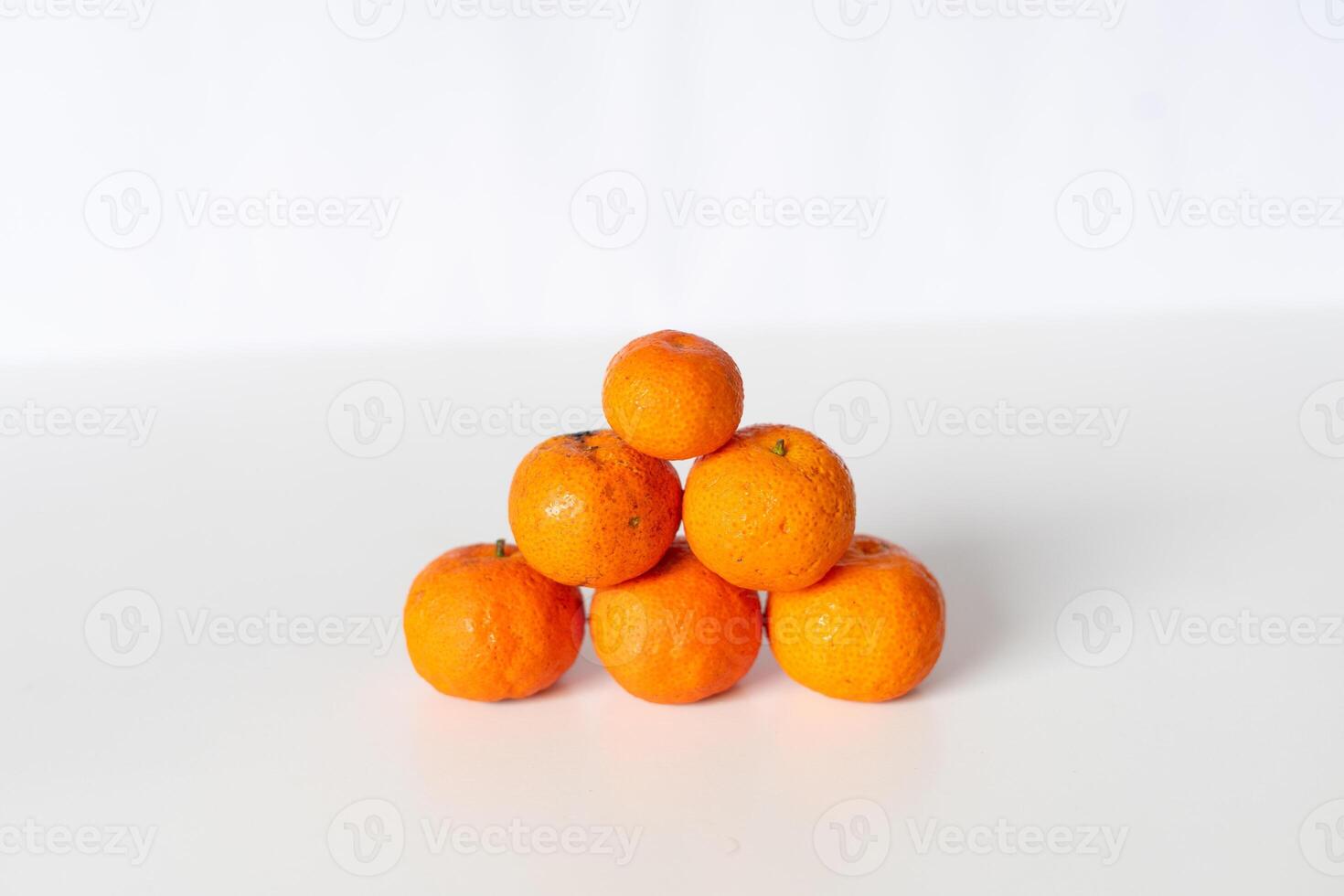 Arrangement of Fresh Tangerines Stacked as Pyramid on White Background photo