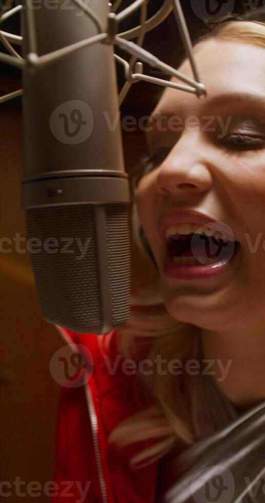 A woman singing in a recording studio photo