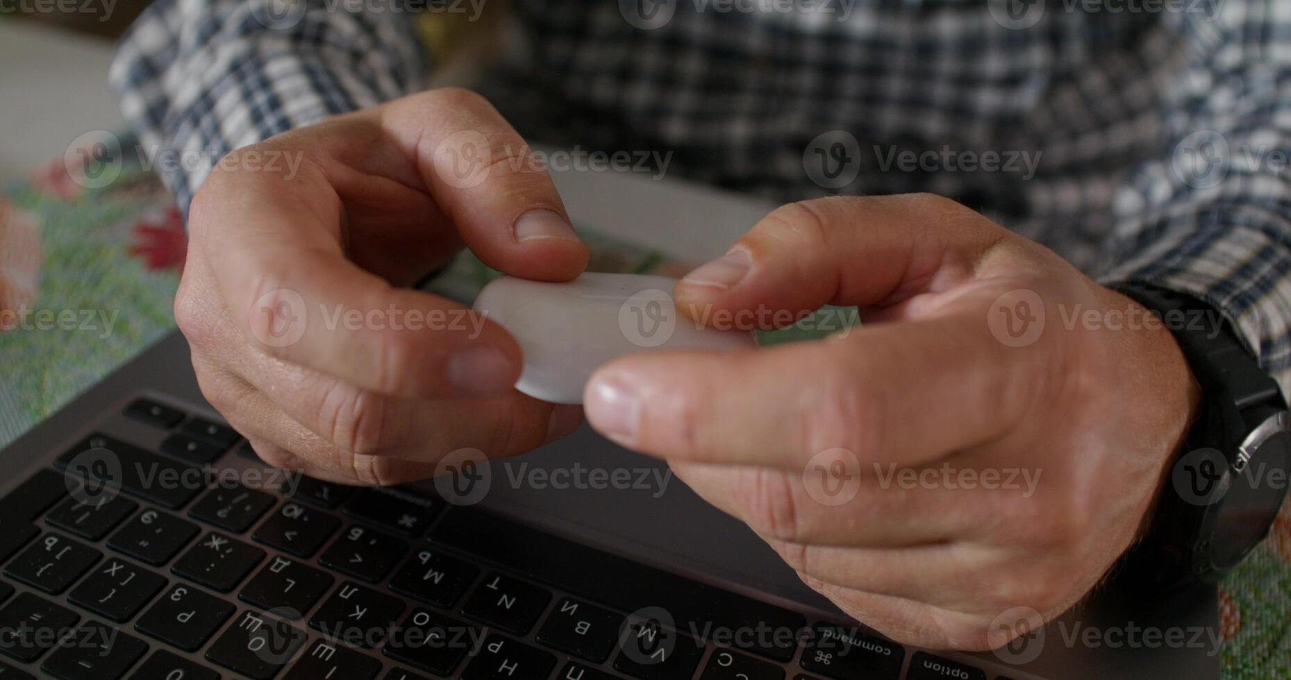 A man is holding a small object in his hands photo