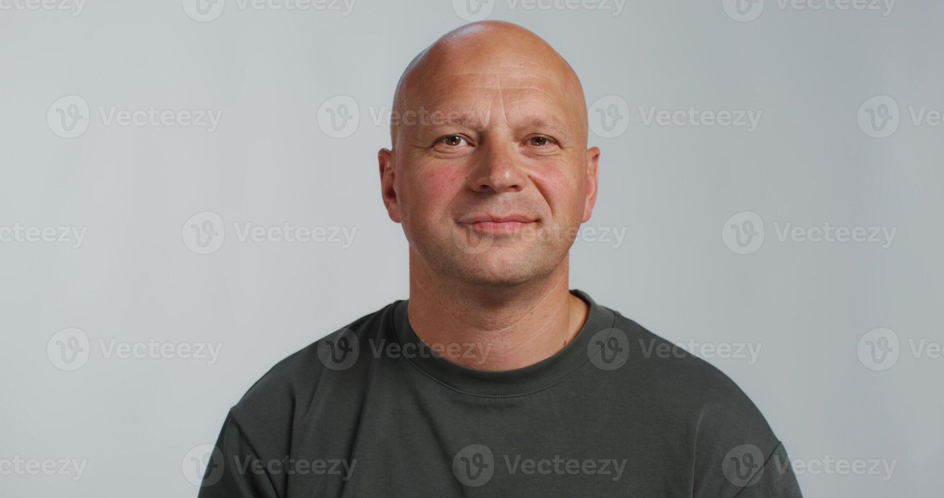 A bald man in a black shirt looking at the camera photo