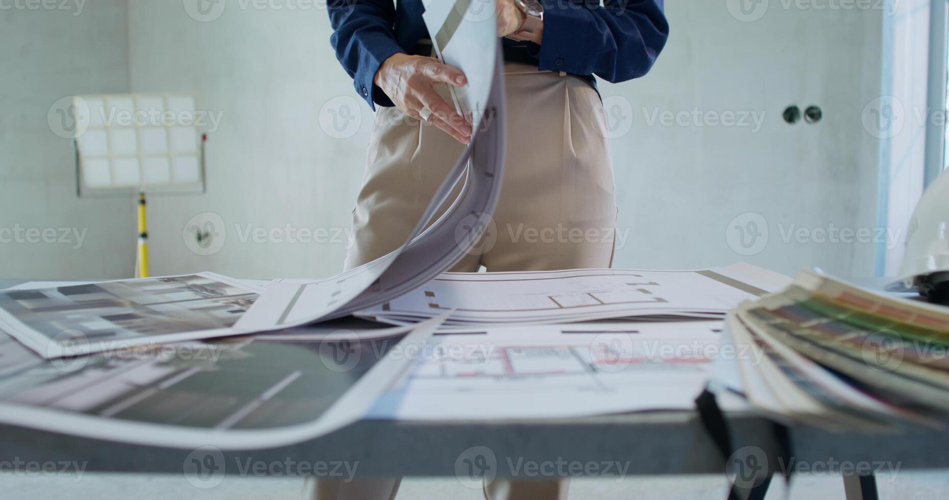 A man is standing in front of a table with architectural plans photo