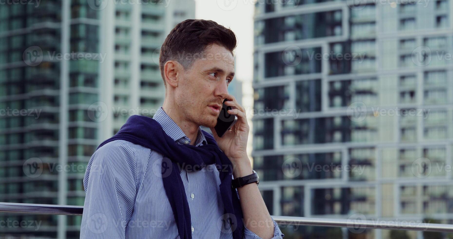 A man in a shirt and tie talking on a cell phone photo