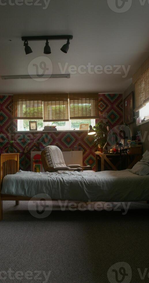 a bedroom interior with patterned wallpaper design and a bed in the middle photo