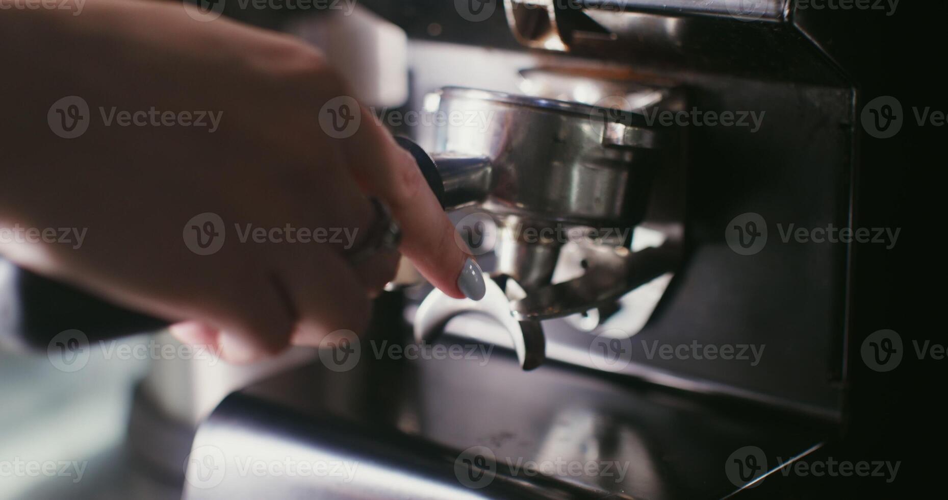 Freshly ground coffee is poured from a coffee grinder into a container photo