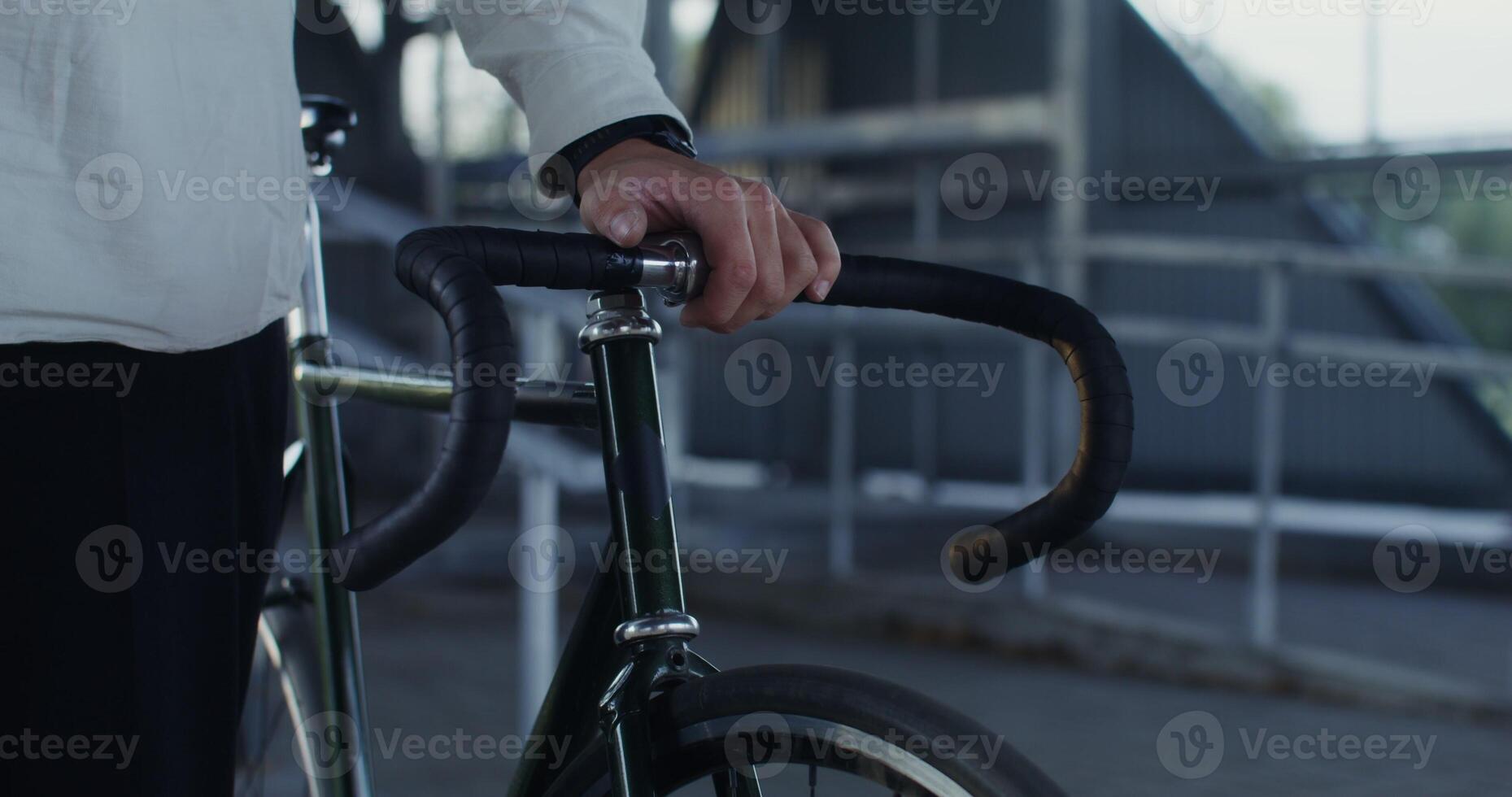 A man holds a bicycle with his hand, an unidentified person photo