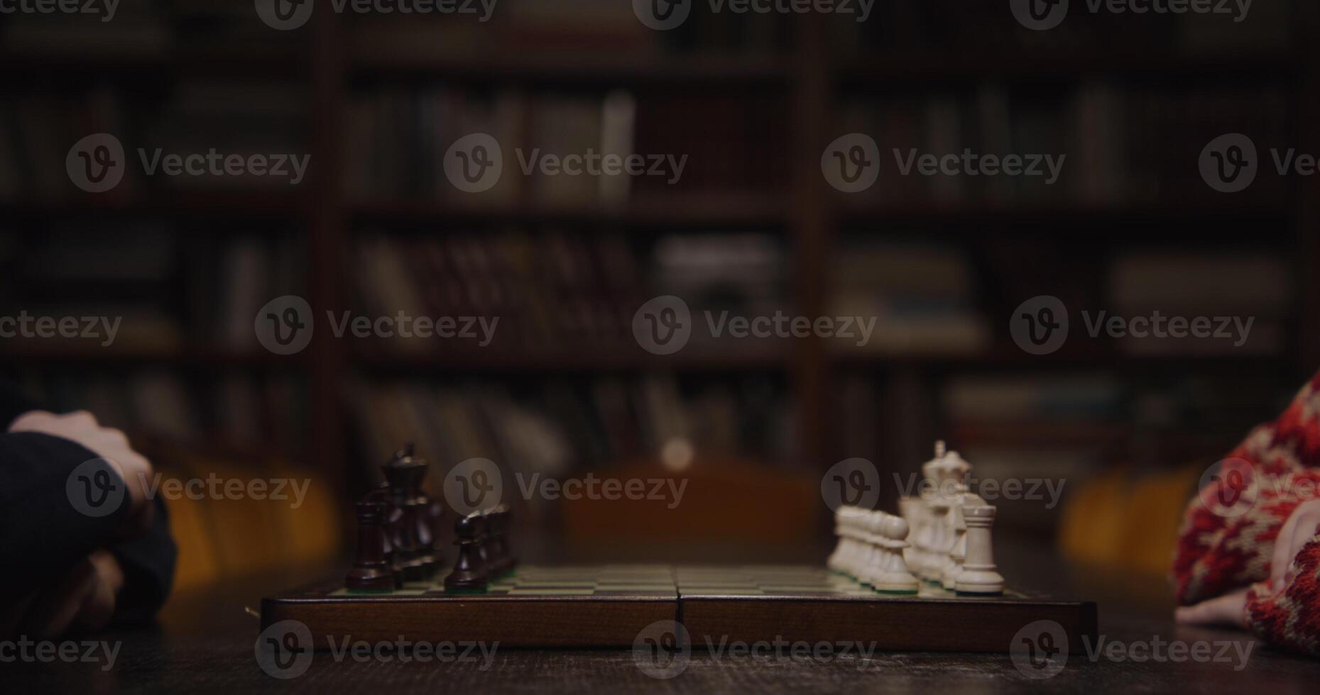 A man and a woman are preparing for a chess game, sitting opposite each other photo