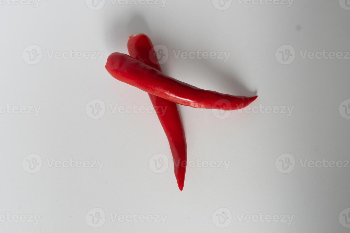 Overlapping vibrant red chili peppers isolated against a simple white background photo