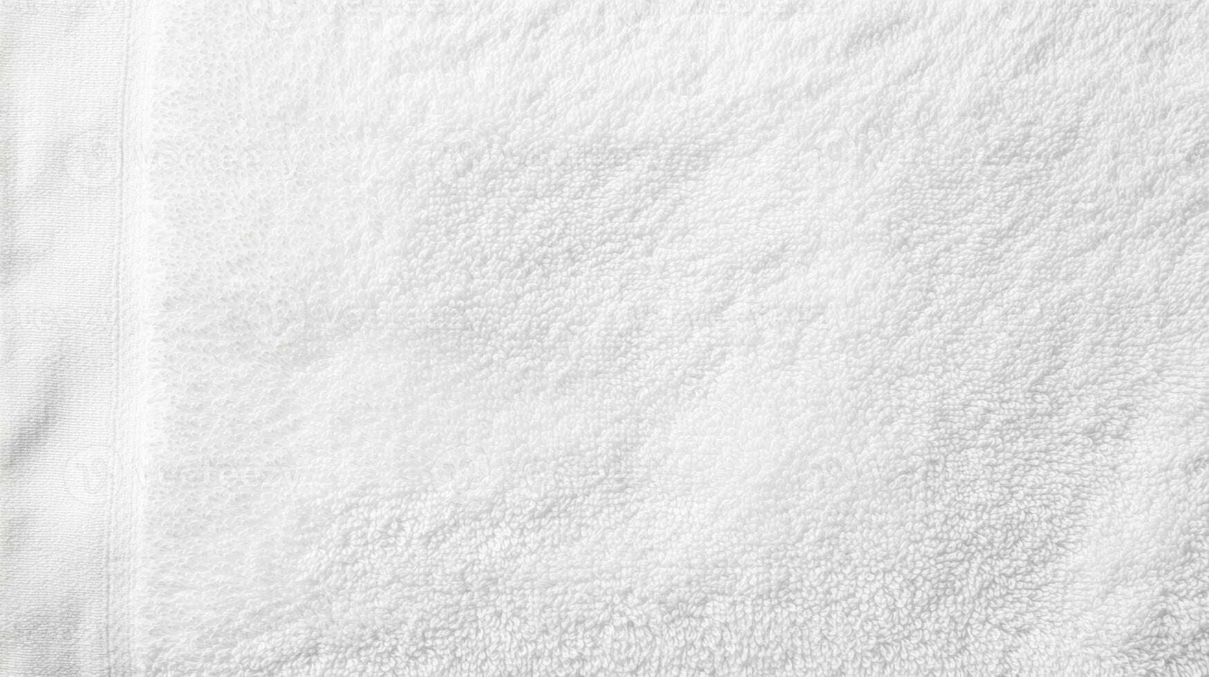 Soft white towel resting on a clean surface, perfect for relaxation and comfort after bathing or swimming photo