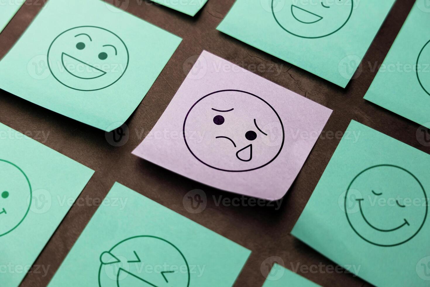 Mind, Mental Health Concept. Mood and Emotion on Sticky Note. Sadness Cartoon Emoticon Face at the center, surrounded by another happy faces photo