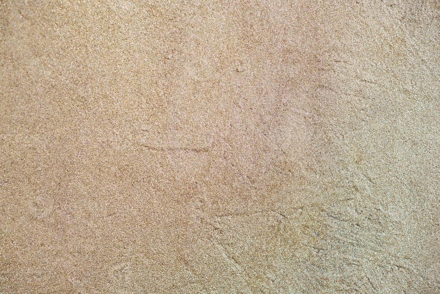 Golden sand texture background with soft patterns. Natural beach surface with fine grains and subtle ripples. photo