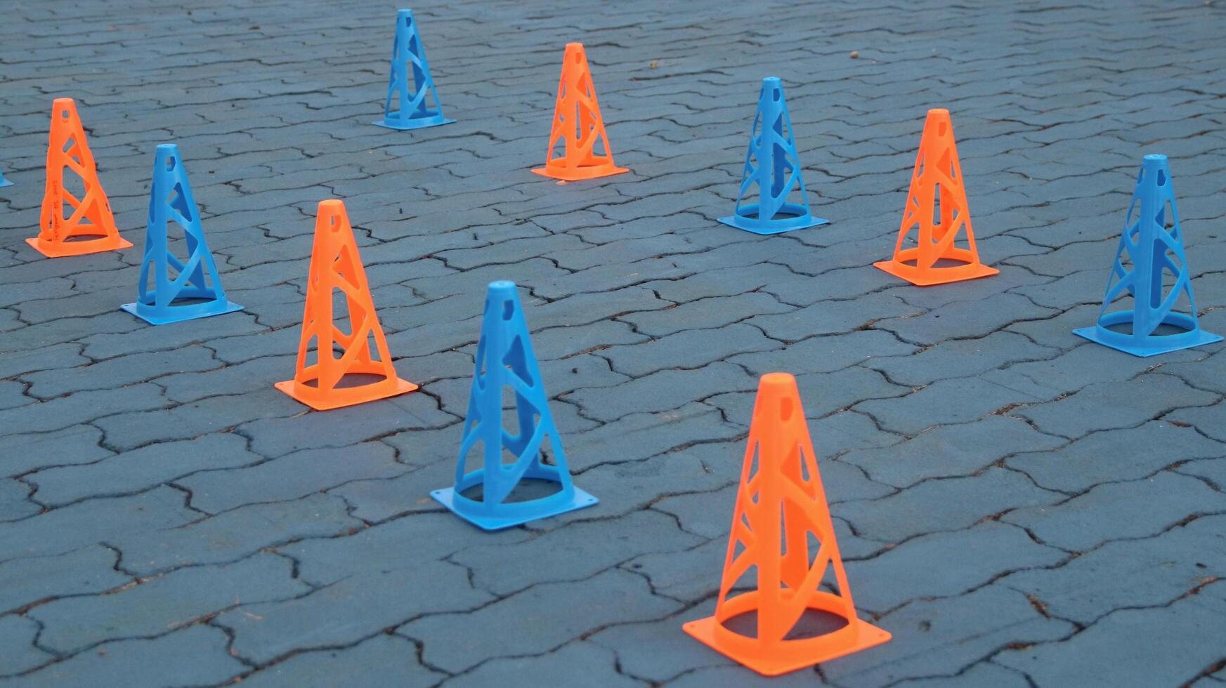 Orange cones and blue cones set up on a blue field for high school sports speed drills, photo