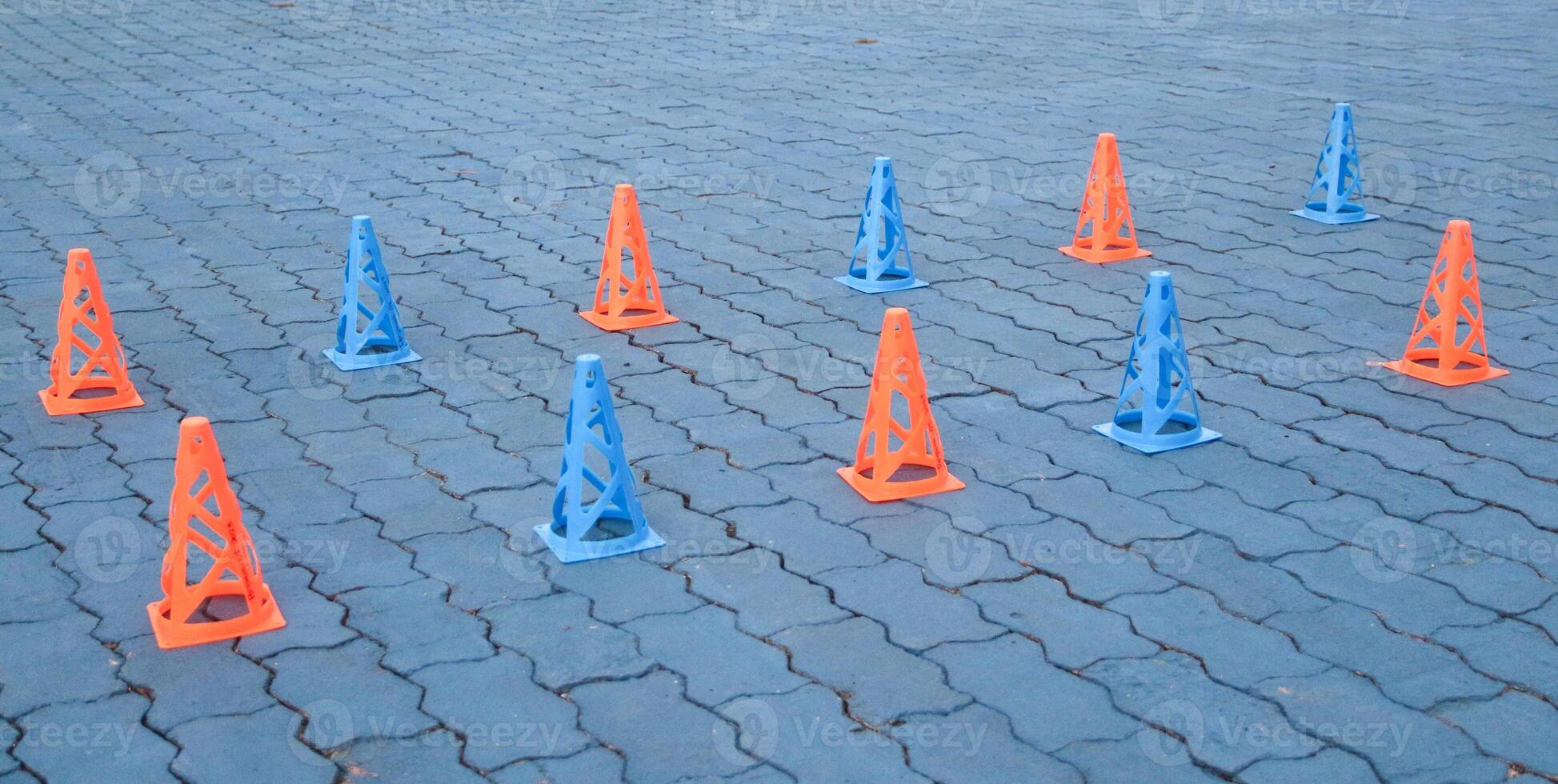 Orange cones and blue cones set up on a blue field for high school sports speed drills photo