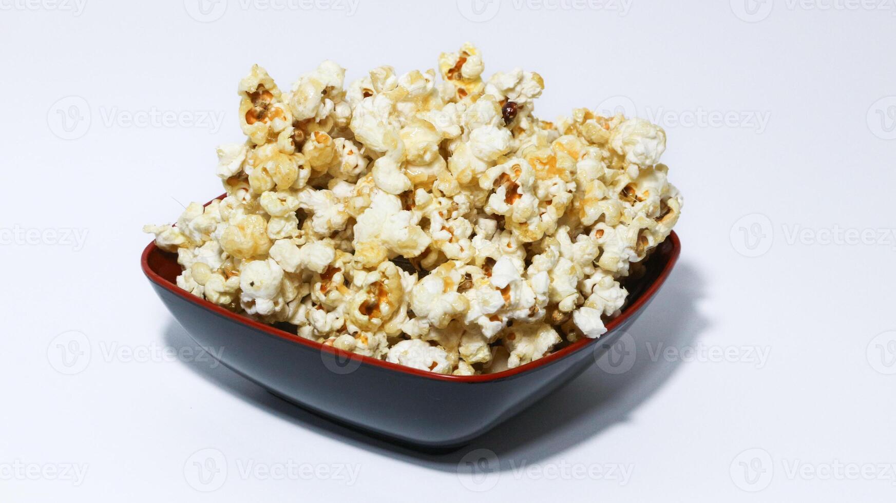 Caramel Popcorn in a black bowl isolated on white background. ready to serve. photo