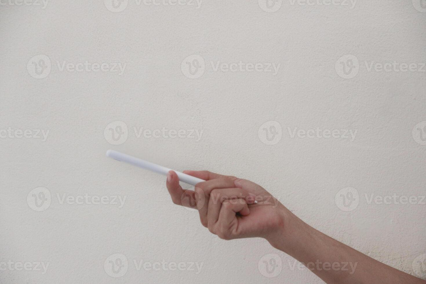 Technology Concept. One Hand using Tablet in Vertical axis with white stylus or pen and free screen photo