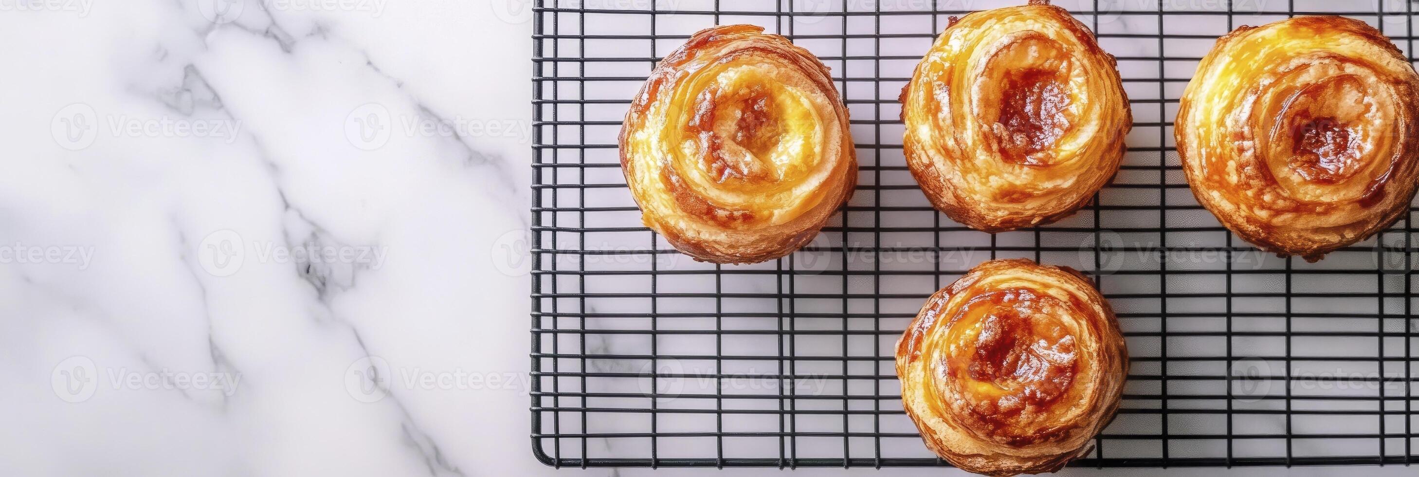 Four pastries on a cooling rack on a marble counter photo