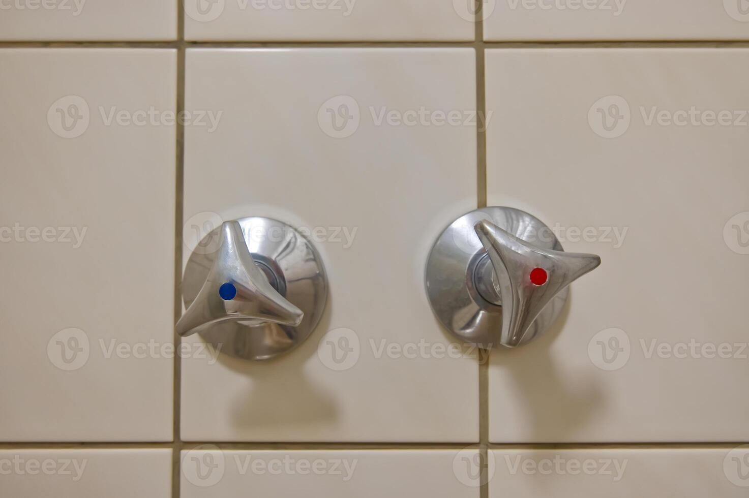 Metal Faucet Knobs on Tiled Wall photo
