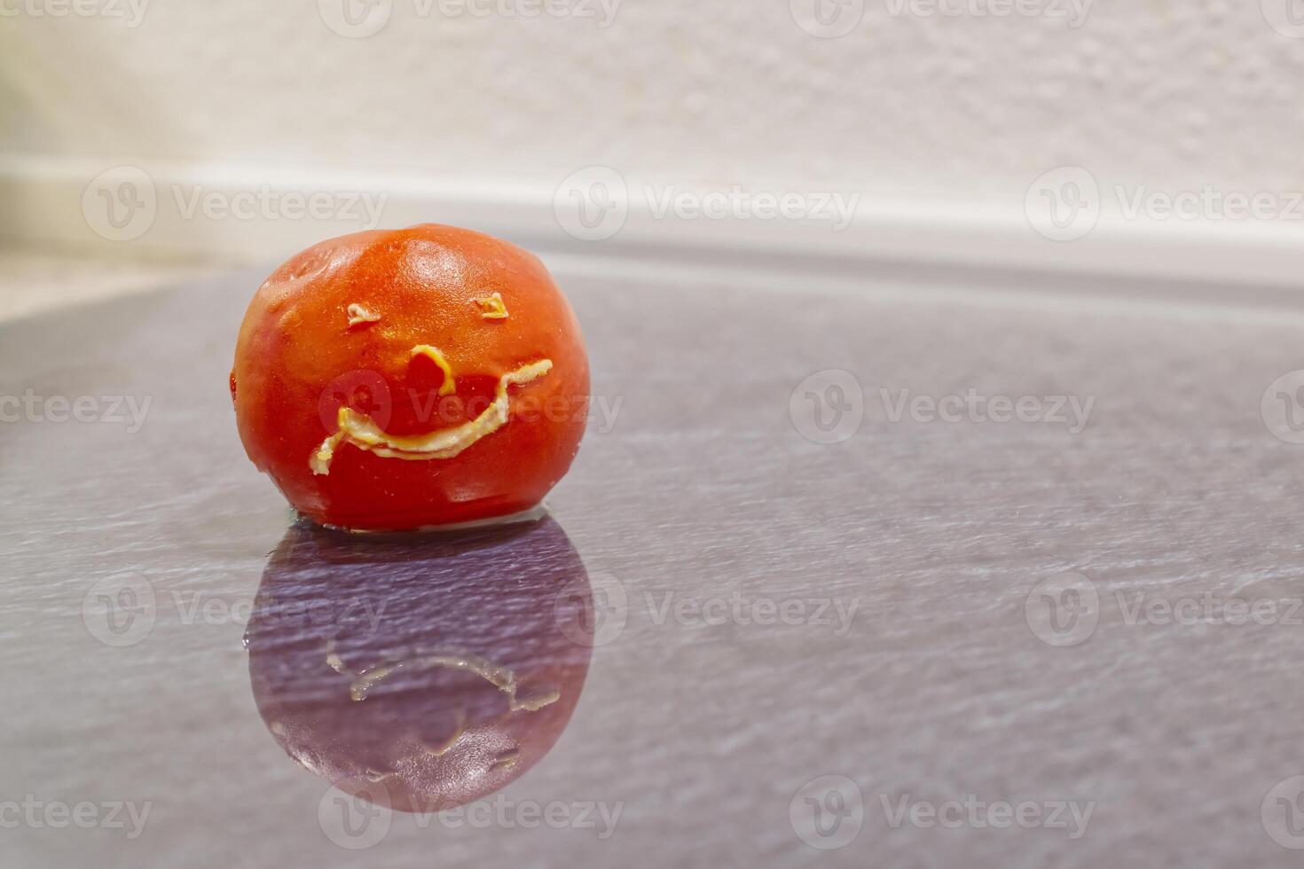Playful Smiling Tomato on Reflective Surface photo