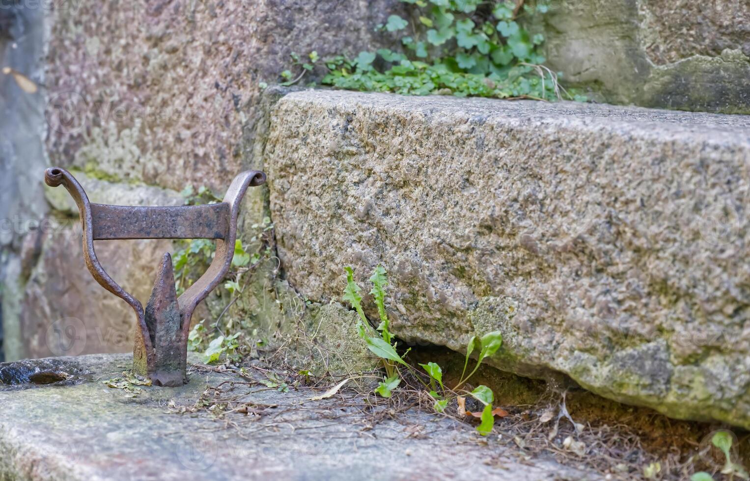 Old Metal Fixture on Weathered Stone Wall photo