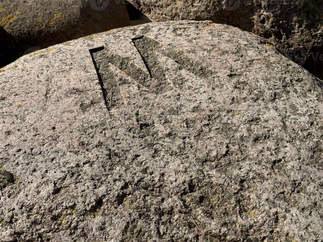 Carved Letter 'M' on Weathered Rock photo
