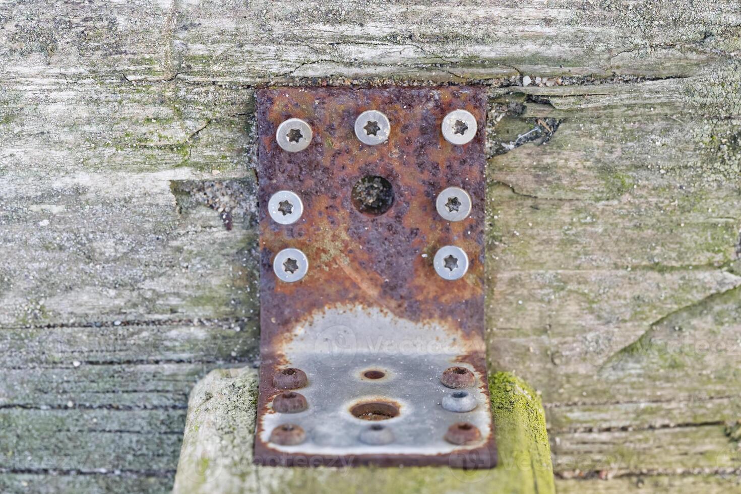 Rusty Metal Bracket on Weathered Wood photo