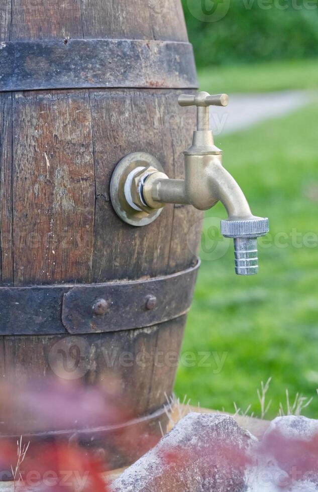 Brass Tap on Wooden Barrel in Garden photo