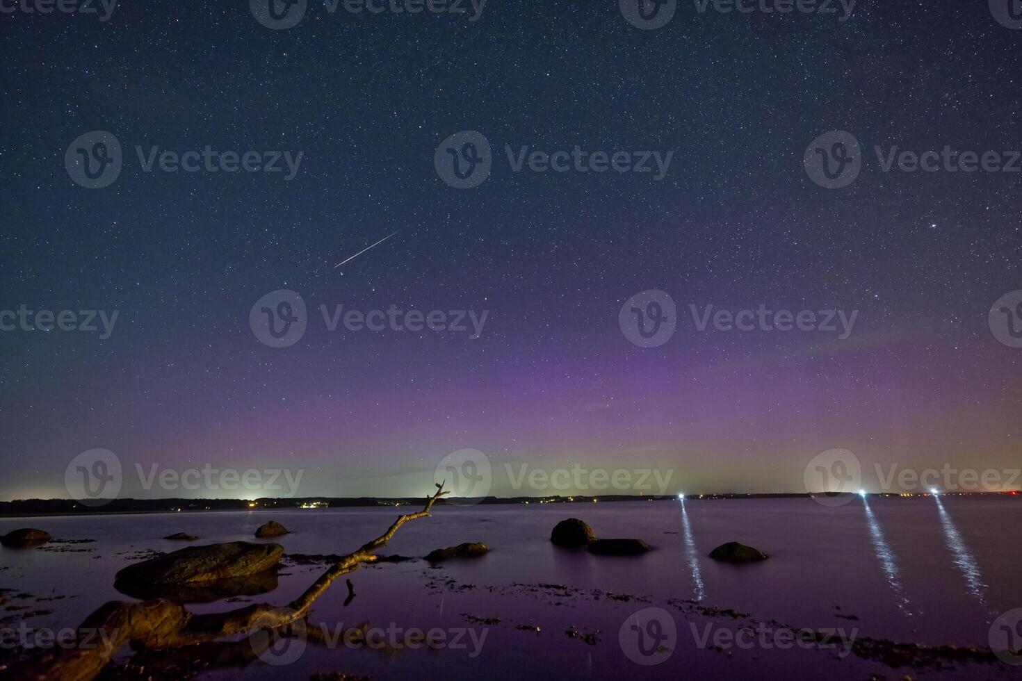 Starry Night with Northern Lights over Calm Waters in Flensburg Germany photo