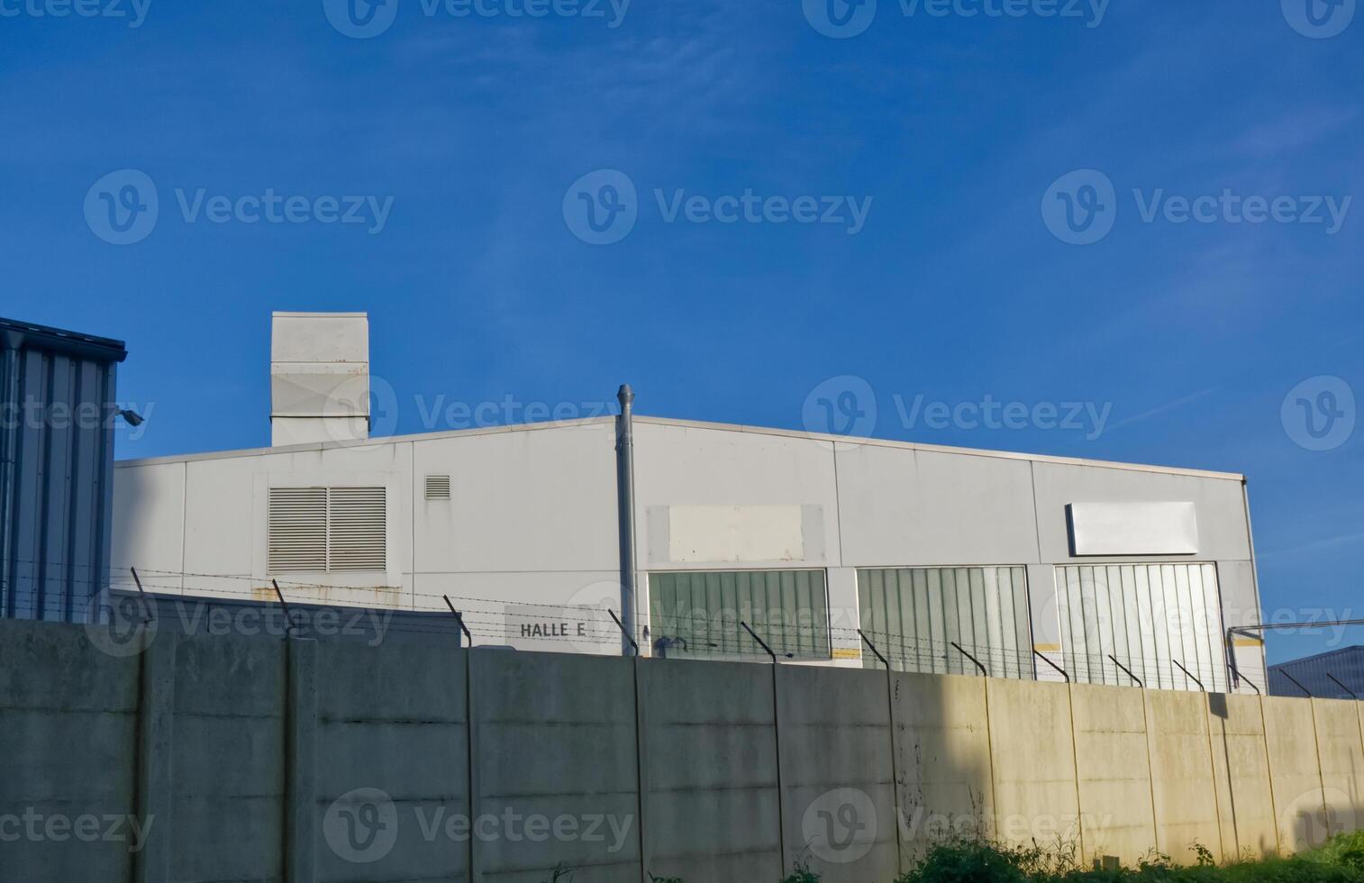 Industrial Building with Ventilation Stack and Concrete Wall photo