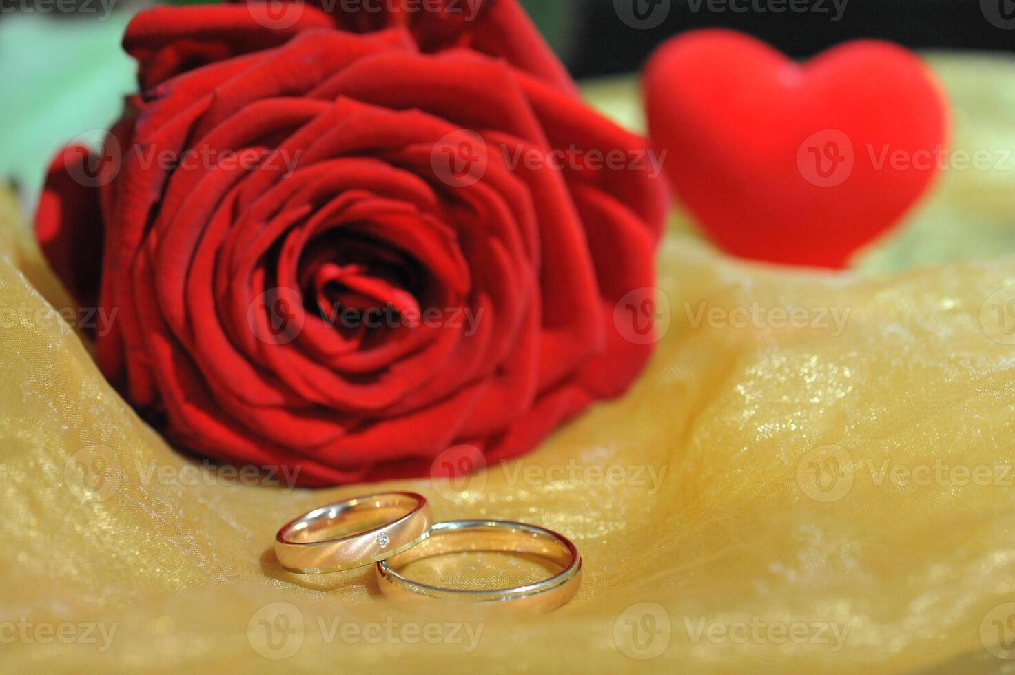 Wedding Rings with Rose and Heart Decoration an golden ground photo
