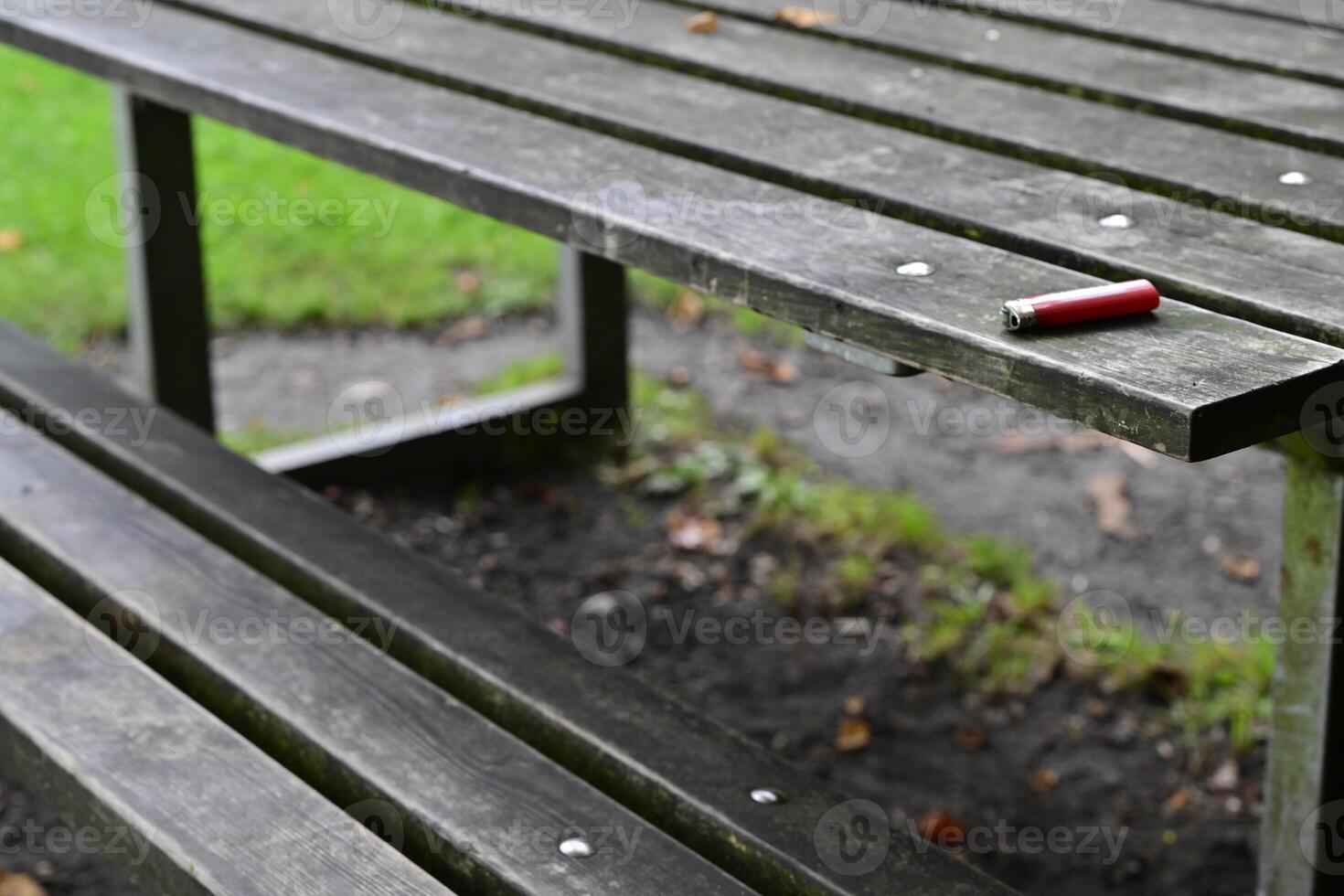 Red Lighter on a Weathered Picnic Table photo