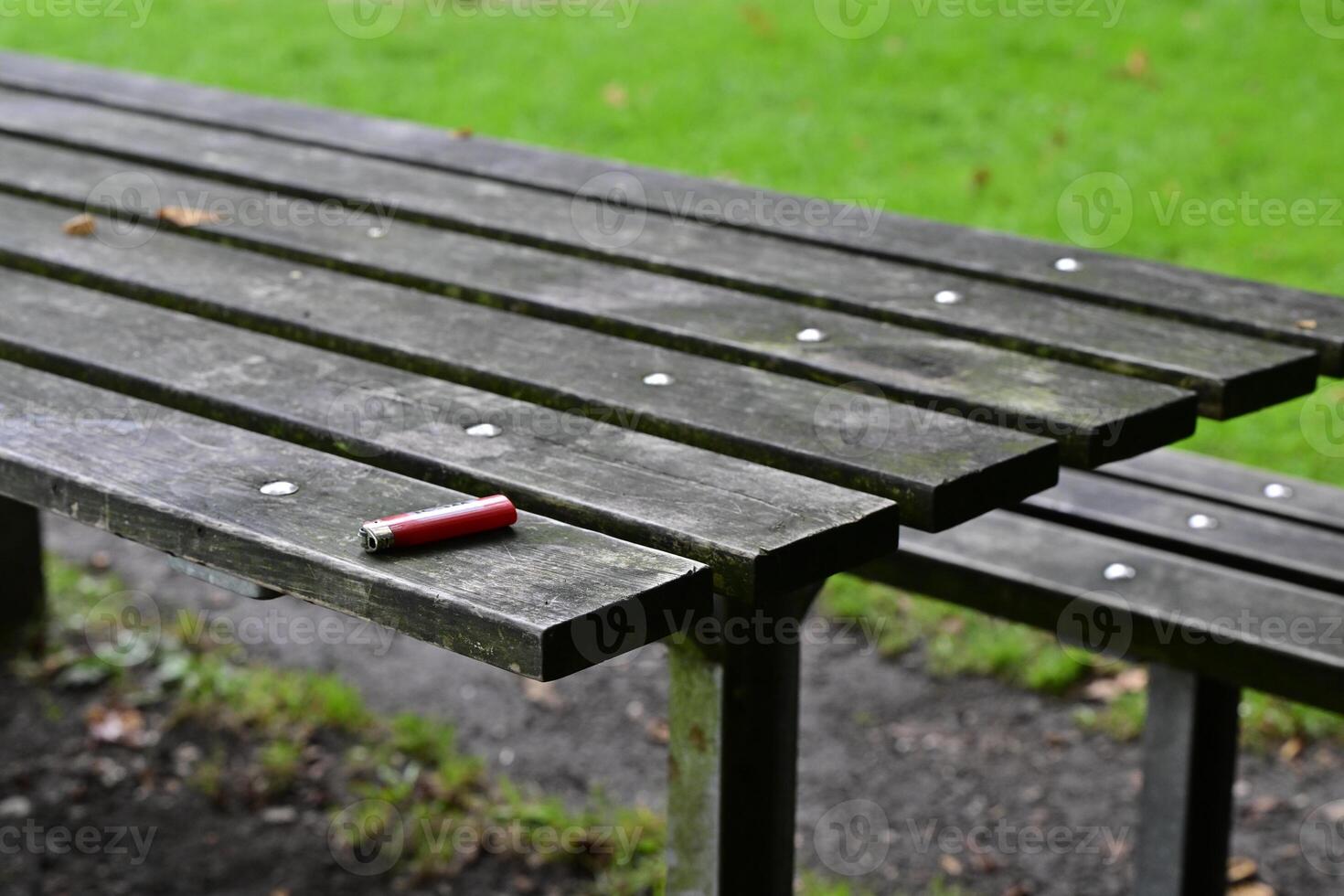 Weathered Picnic Table with Red Lighter photo
