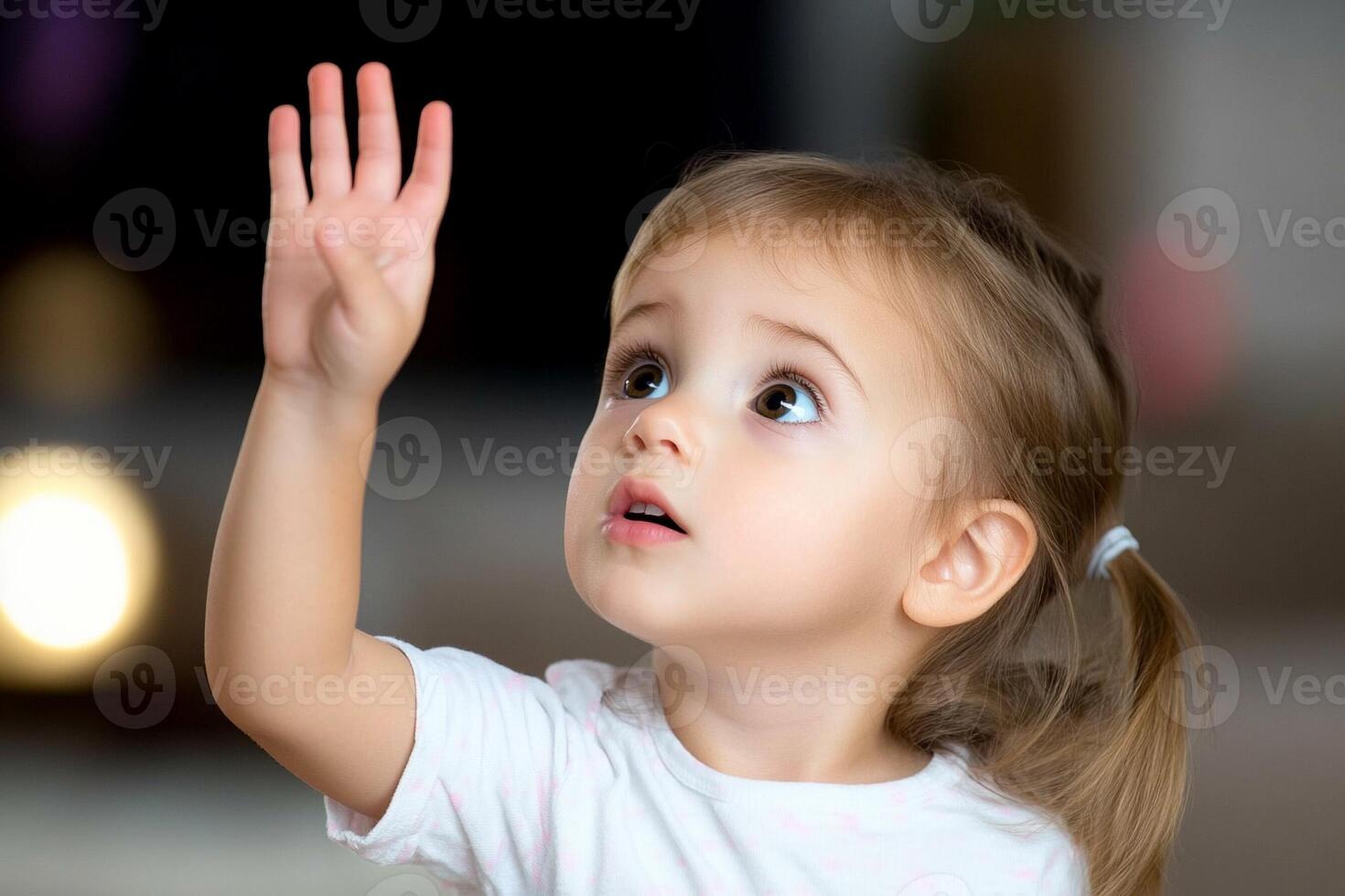 A little girl reaching up to get something photo