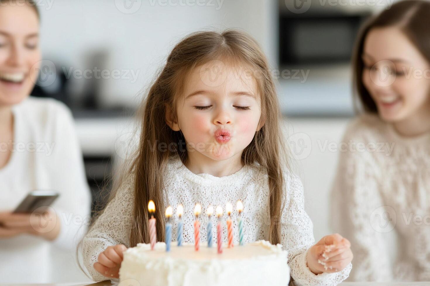 A little girl blowing out candles on a birthday cake photo