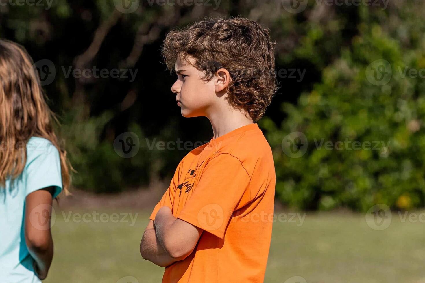 A boy and girl standing in a field photo