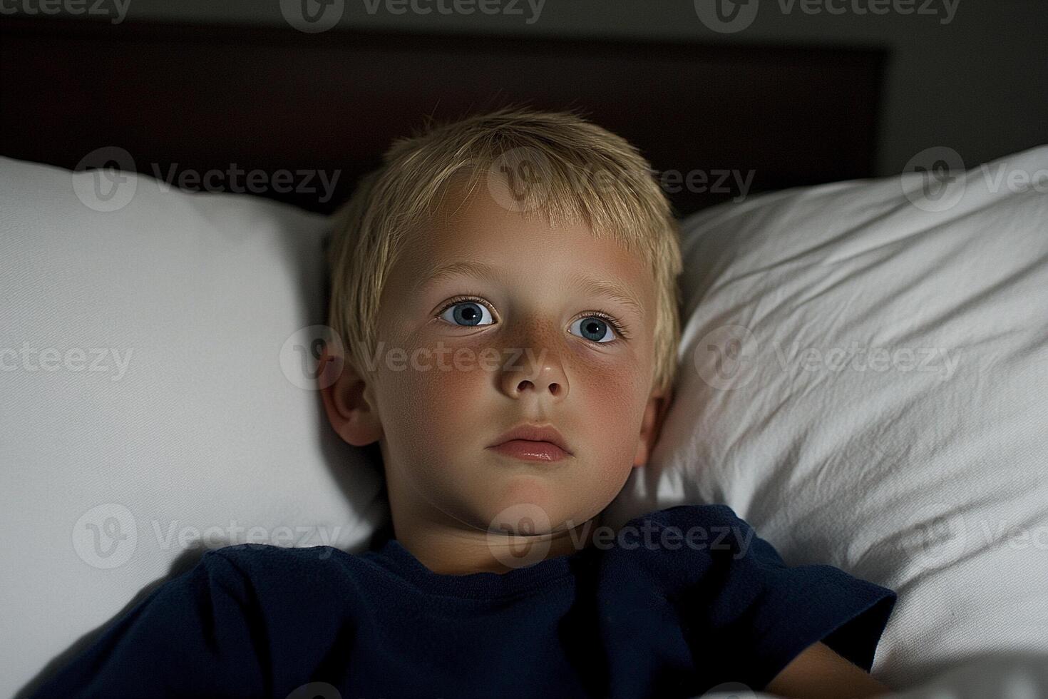 A young boy laying in bed photo