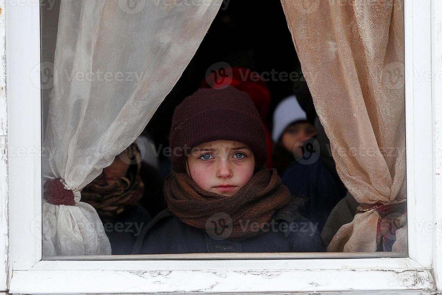 A boy looks out the window of a building photo