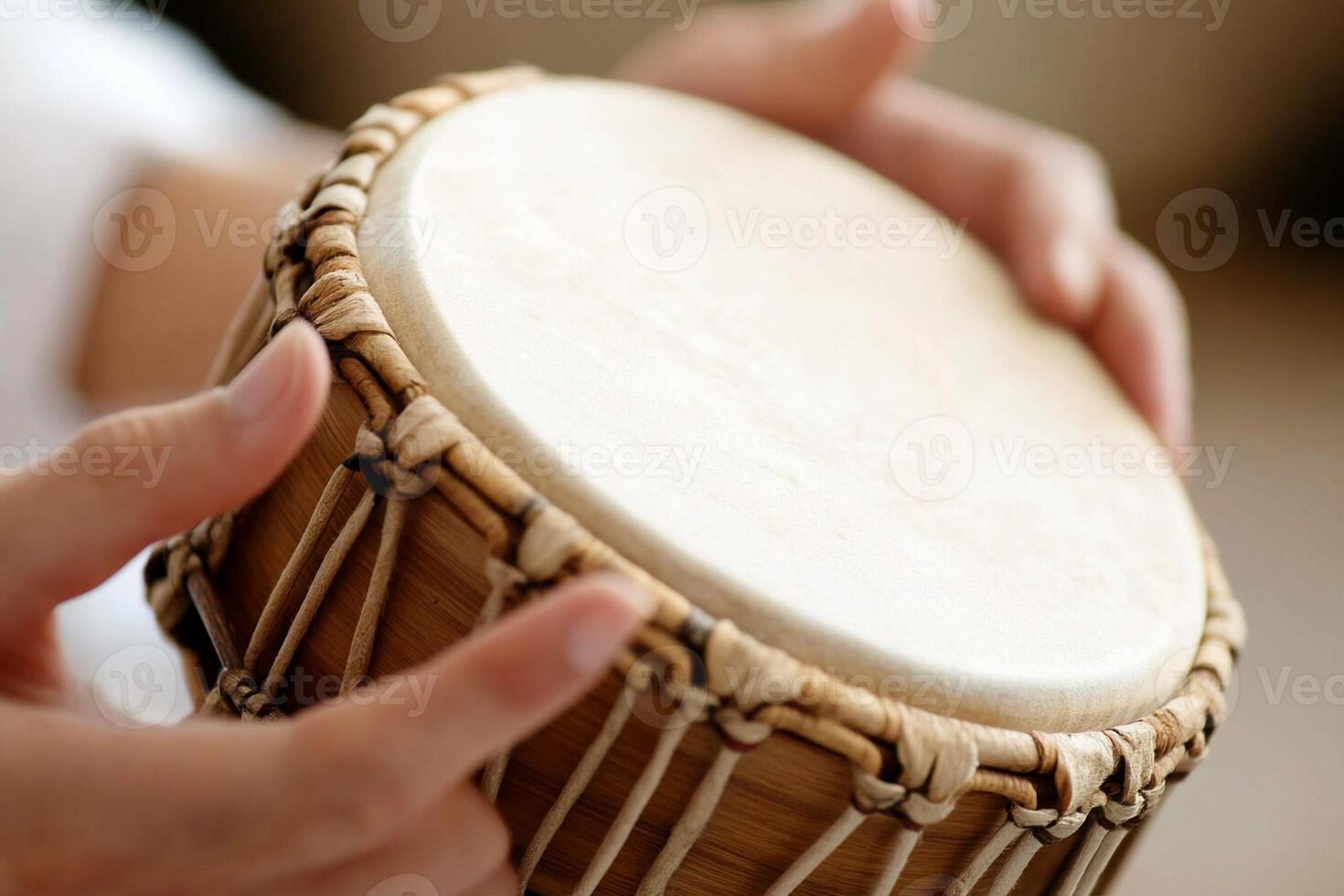 A person is playing a drum with their hands photo