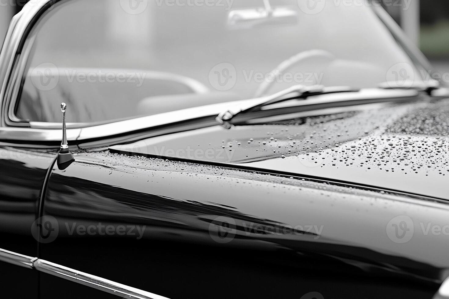 A black and white photo of a car with rain drops on it