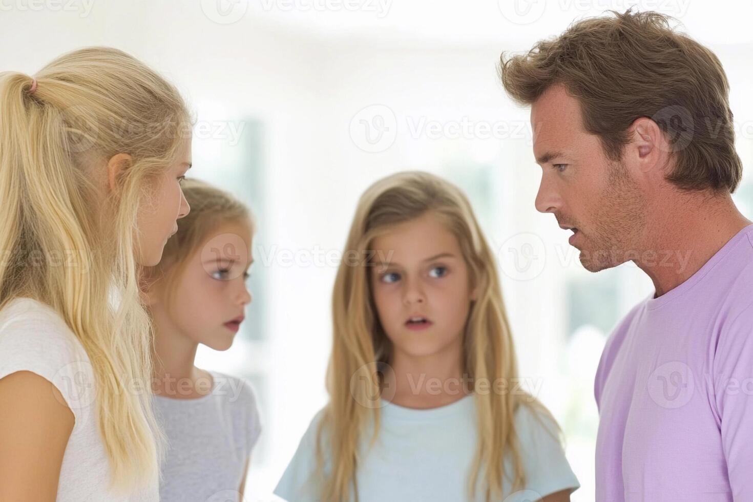 A man talking to two girls and a woman photo