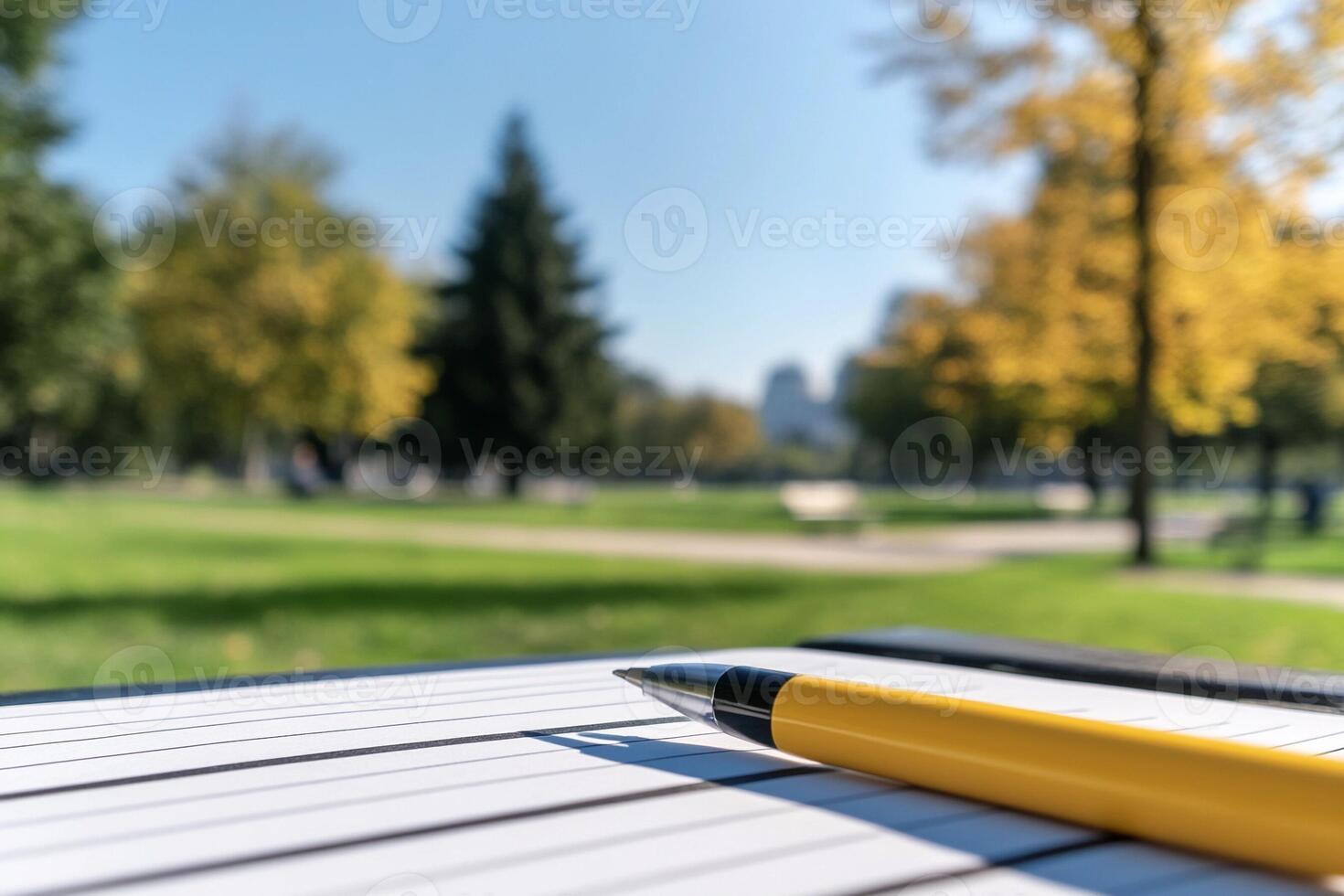Pen and notebook on a park bench photo