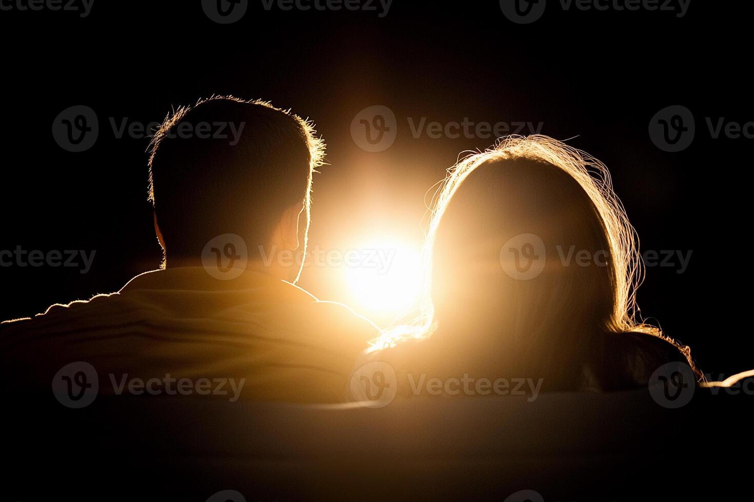 Couple sitting on sofa with the sun shining behind them photo