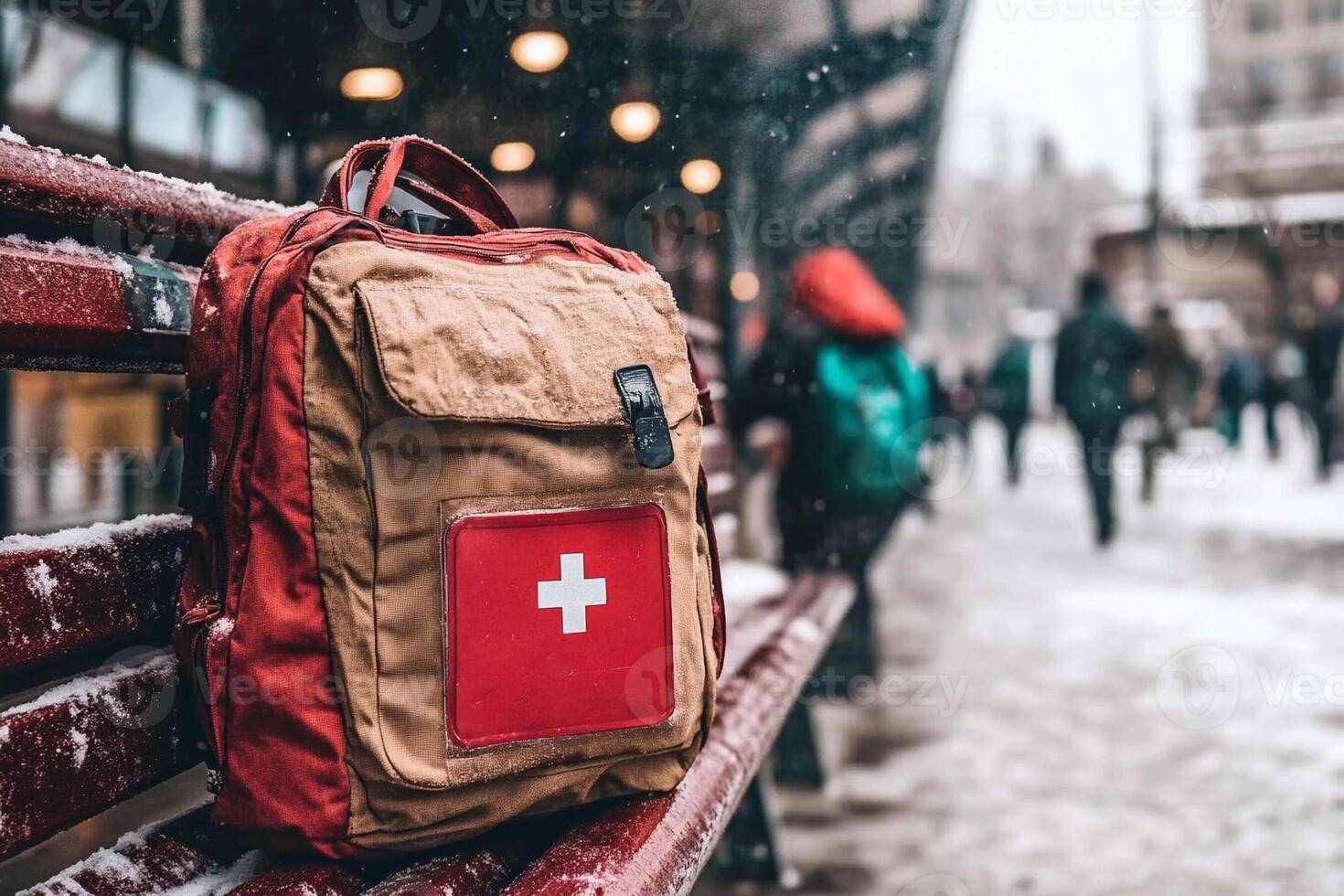 A backpack with a swiss cross on it sits on a bench in the snow photo