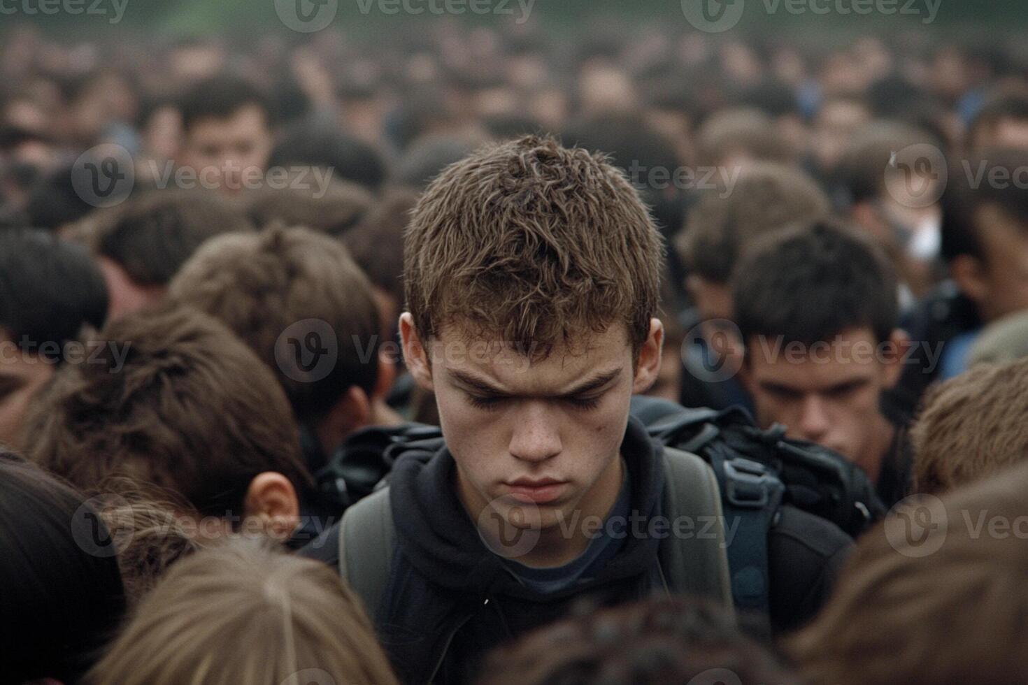 A young man standing in a crowd of people photo
