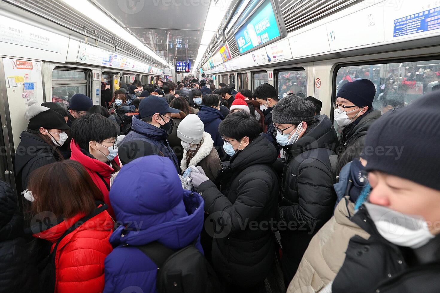 People wearing face masks on a subway train photo