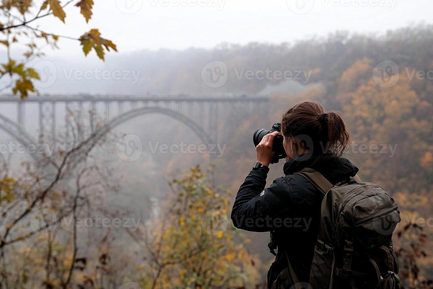 A woman taking a picture of a bridge photo