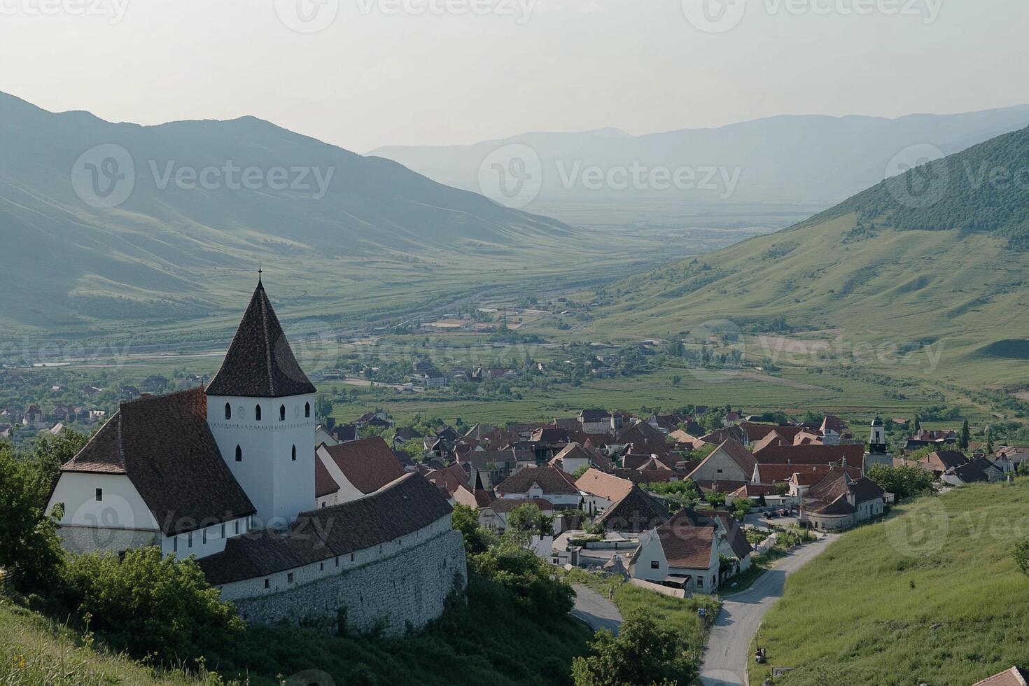 A church sits on top of a hill in the middle of a valley photo